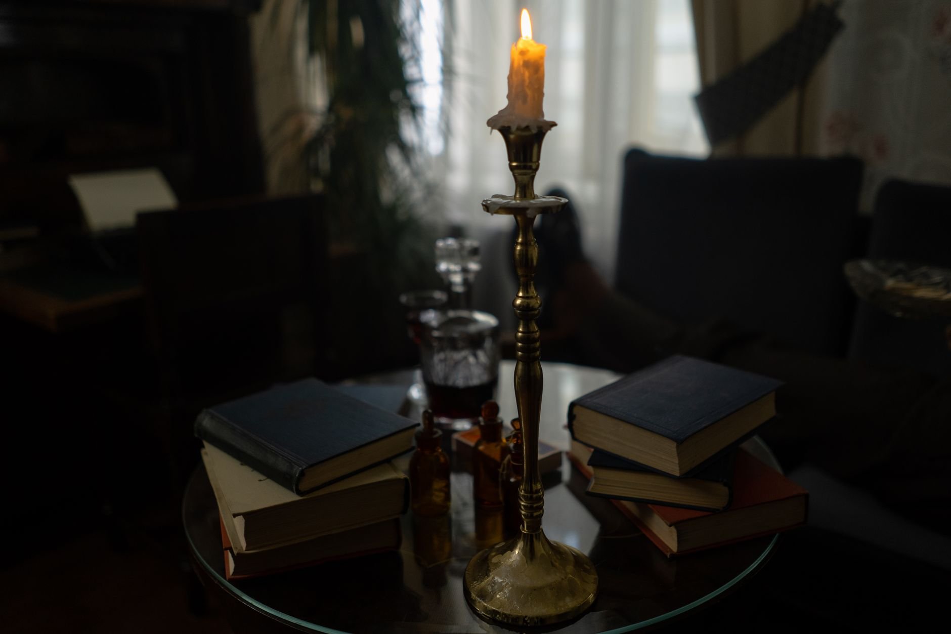 A cozy indoor scene with stacked books and a candle, creating a warm and inviting atmosphere